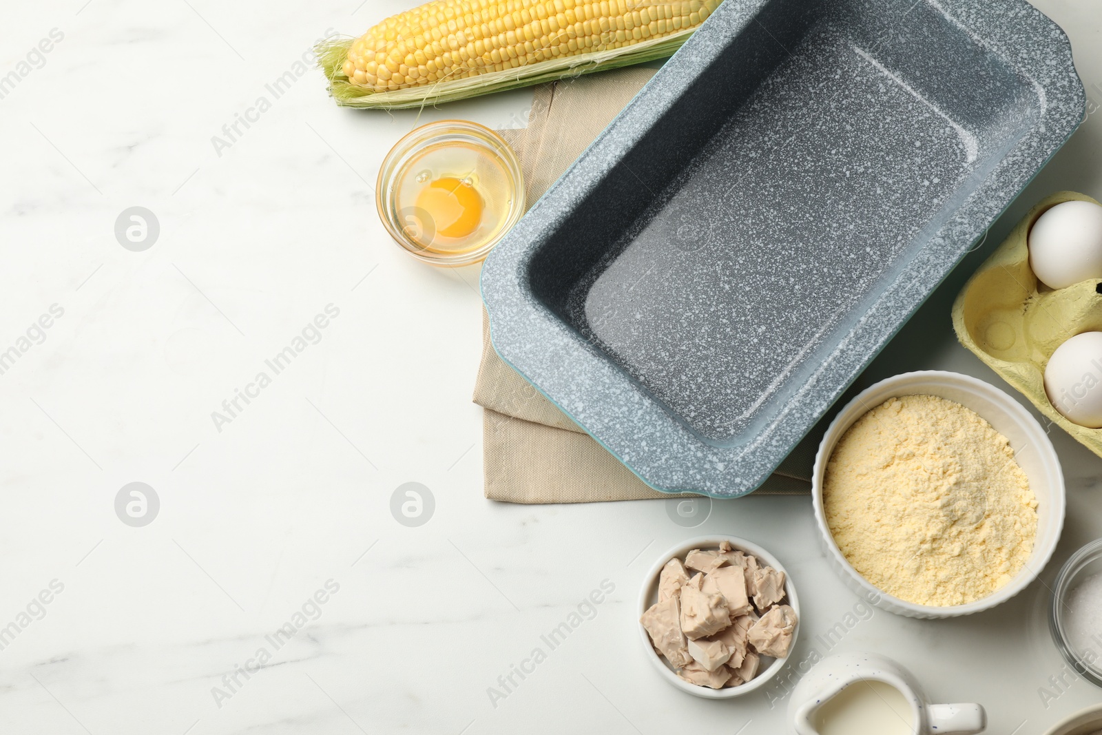 Making cornbread. Different ingredients and baking dish on white marble table, flat lay. Space for text Photo of Making cornbread. Different ingredients and baking dish on white marble table, flat lay. Space for text