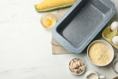 Photo of Making cornbread. Different ingredients and baking dish on white marble table, flat lay. Space for text