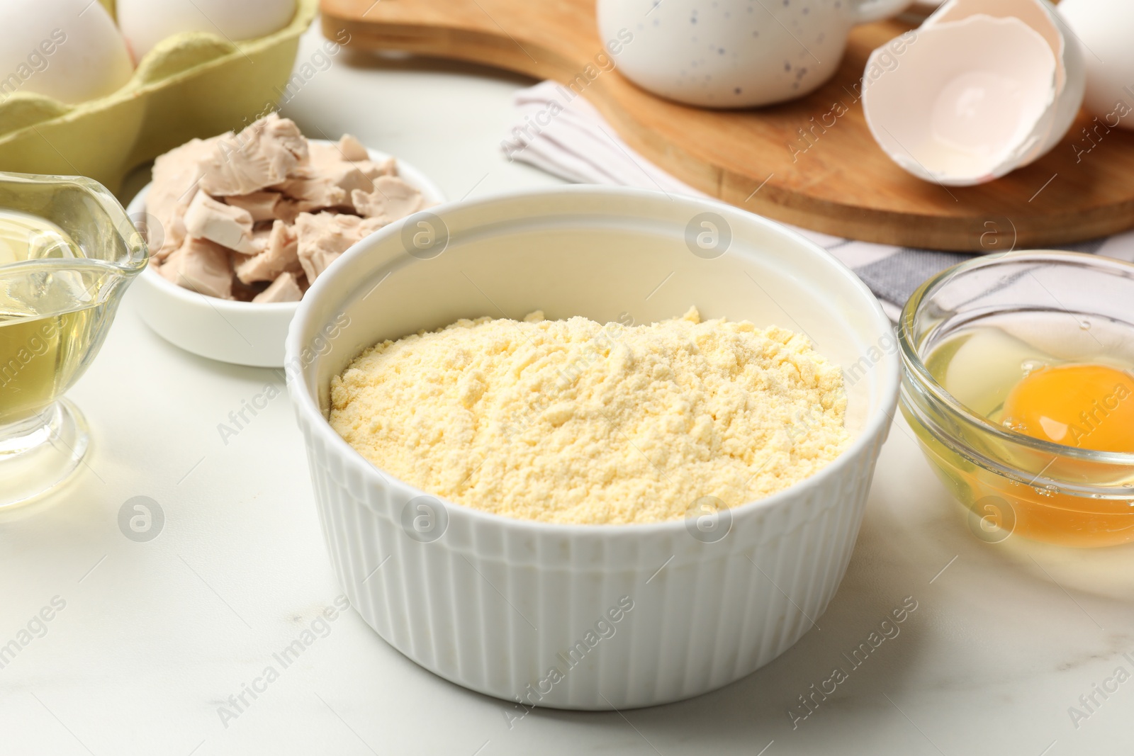 Photo of Making cornbread. Different ingredients on white marble table, closeup