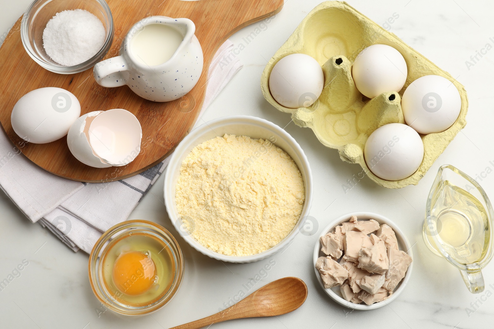 Photo of Making cornbread. Different ingredients on white marble table, flat lay