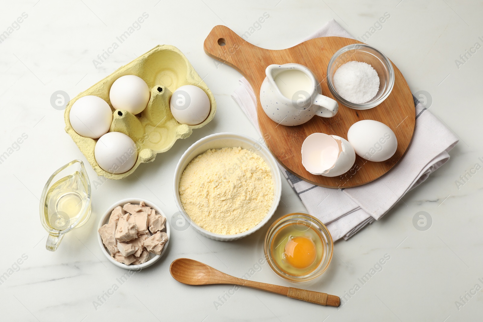 Making cornbread. Different ingredients on white marble table, flat lay Photo of Making cornbread. Different ingredients on white marble table, flat lay