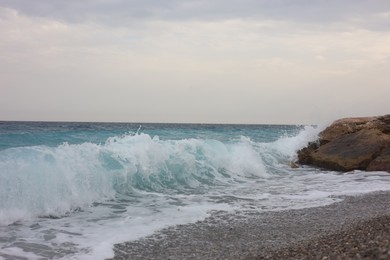 Photo of Beautiful view of wavy sea and pebbles on beach
