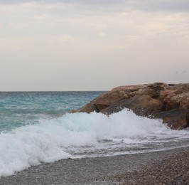 Photo of Beautiful view of wavy sea and pebbles on beach