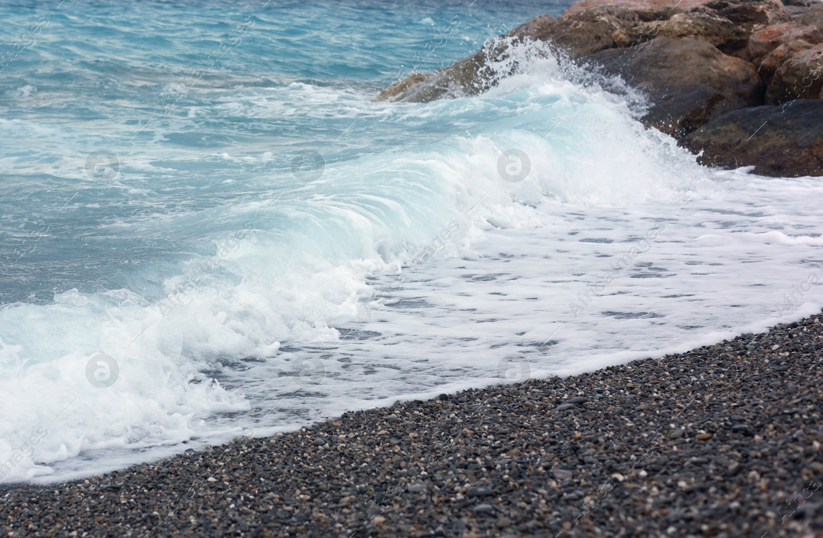 Photo of Beautiful view of wavy sea and pebbles on beach
