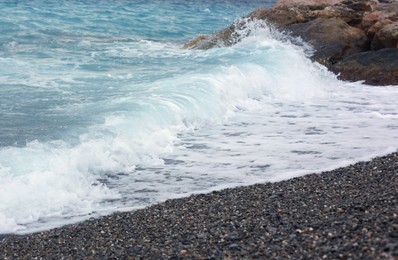 Photo of Beautiful view of wavy sea and pebbles on beach