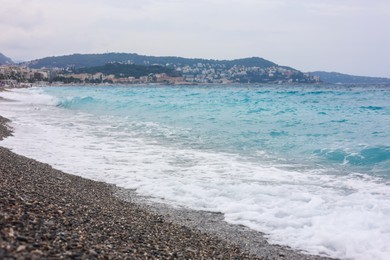 Photo of Beautiful view of wavy sea and pebbles on beach