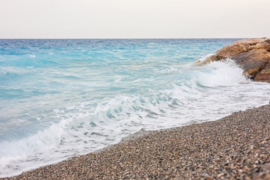 Photo of Beautiful view of wavy sea and pebbles on beach