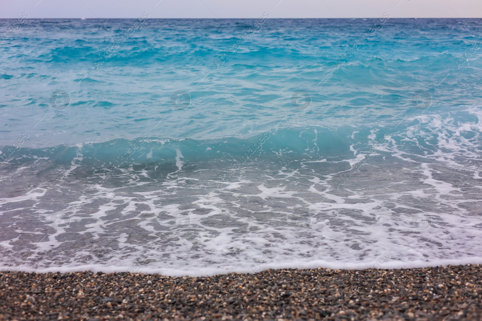 Photo of Beautiful view of wavy sea and pebbles on beach