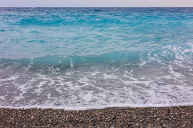 Photo of Beautiful view of wavy sea and pebbles on beach