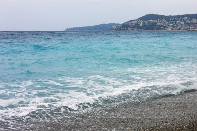 Photo of Beautiful view of wavy sea and pebbles on beach
