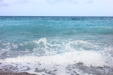 Photo of Beautiful view of wavy sea and pebbles on beach