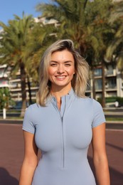 Photo of Portrait of happy young woman in sportswear outdoors