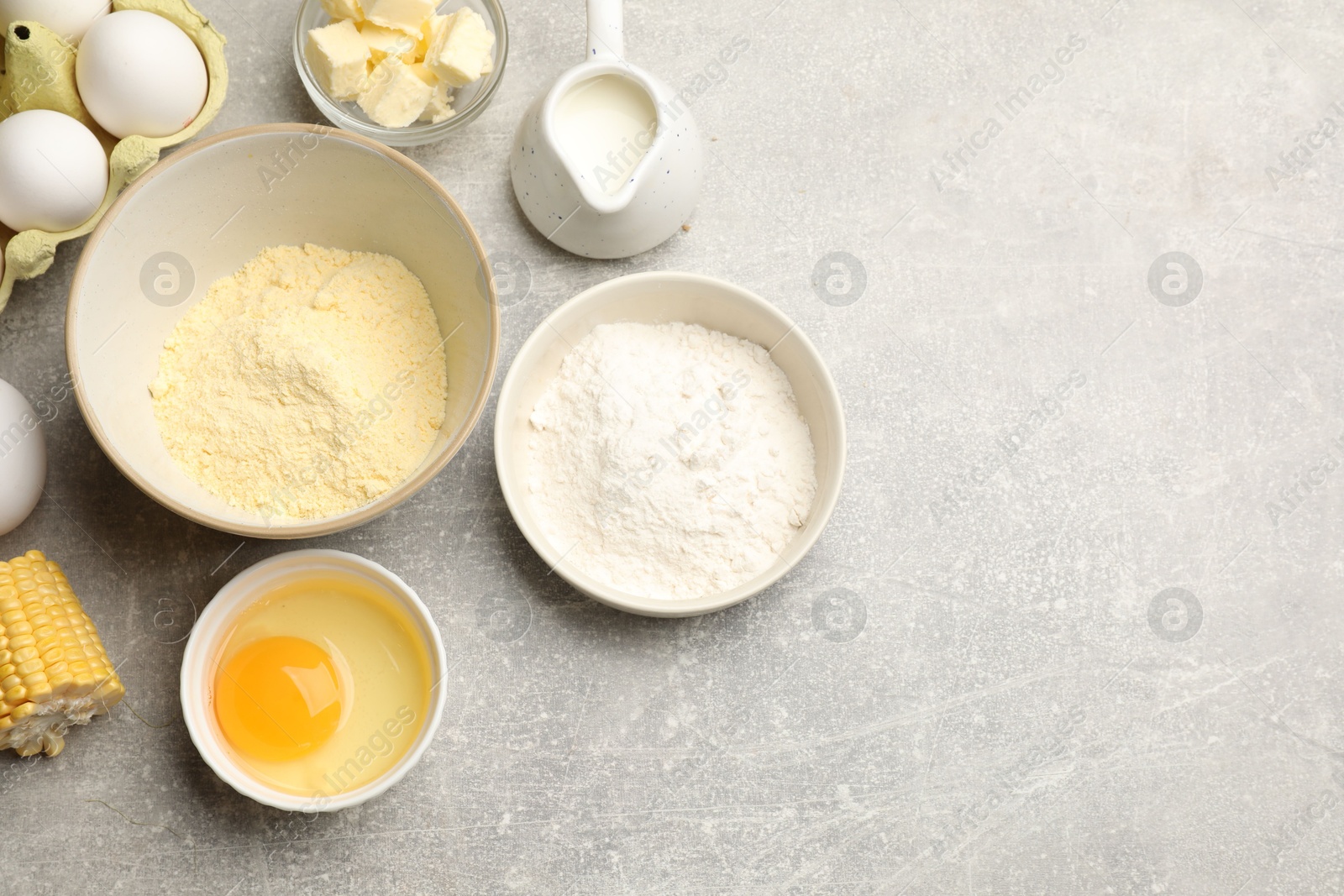 Photo of Cornbread preparation. Different ingredients on light grey table, flat lay. Space for text
