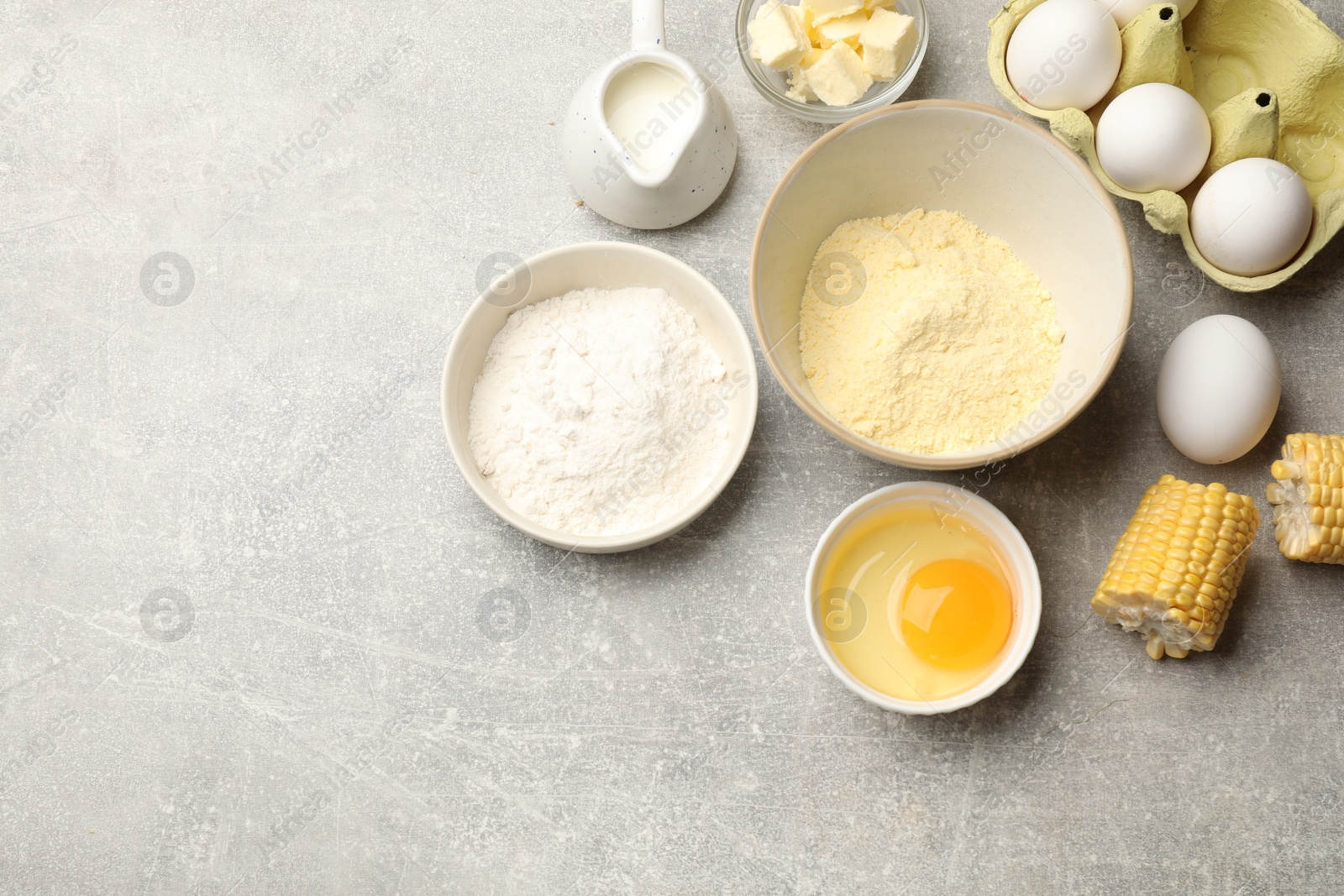 Photo of Cornbread preparation. Different ingredients on light grey table, flat lay. Space for text