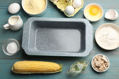 Photo of Cornbread preparation. Baking dish surrounded by different ingredients on light blue wooden table, flat lay