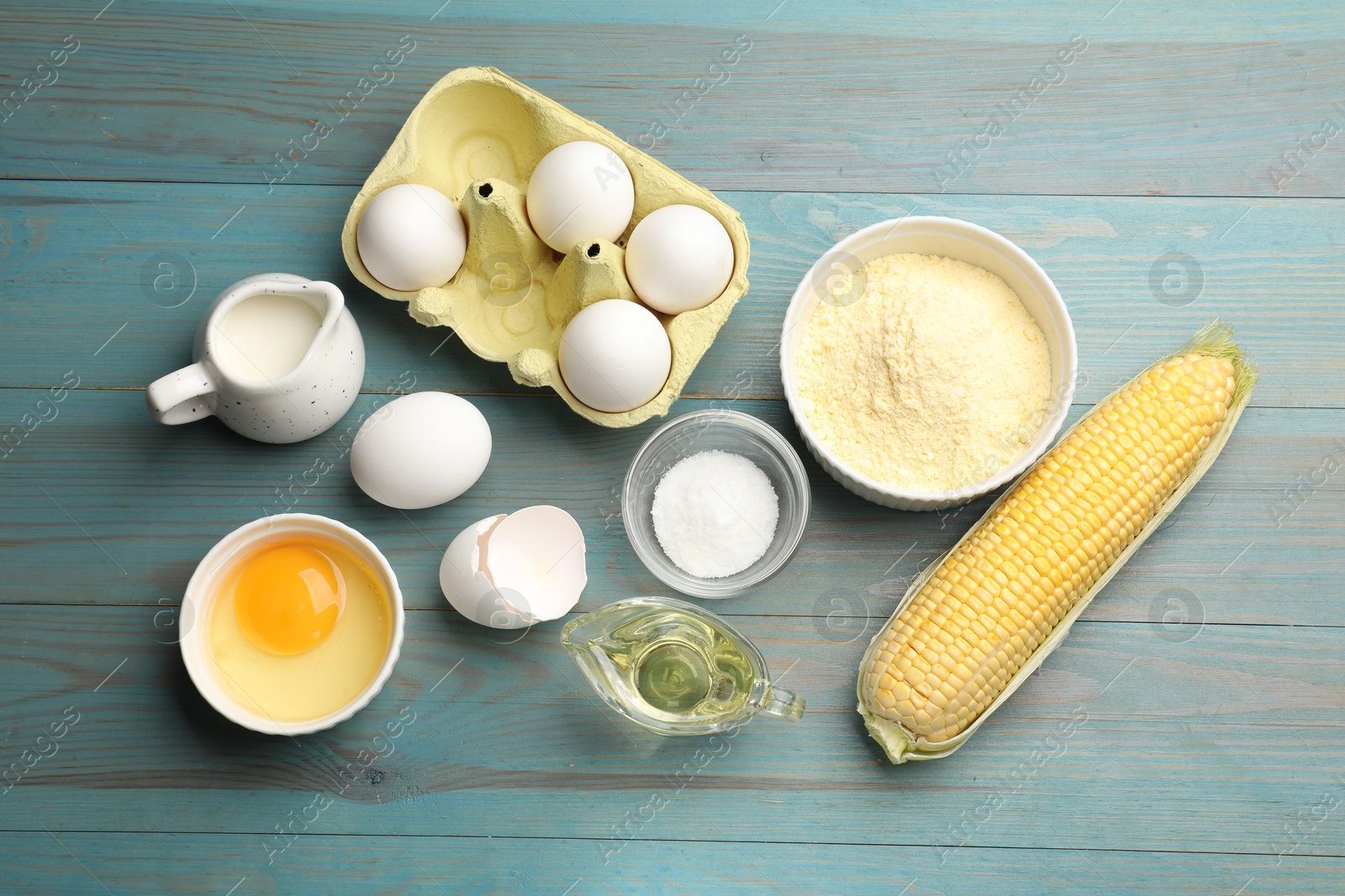 Photo of Cornbread preparation. Different ingredients on light blue wooden table, flat lay
