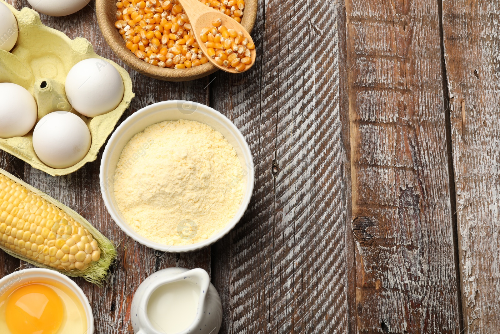 Photo of Cornbread preparation. Different ingredients on wooden table, flat lay. Space for text