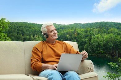 Image of Senior man listening to sounds of nature which making him feel calm. Beautiful landscape on background