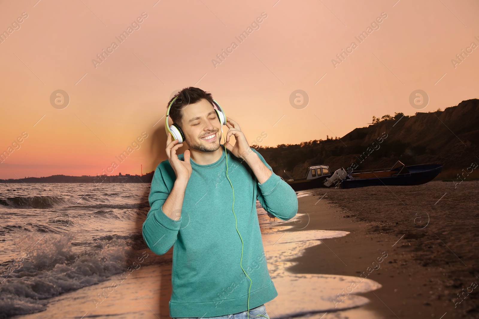 Image of Happy man listening to sounds of nature which making him feel calm. Beautiful seascape on background