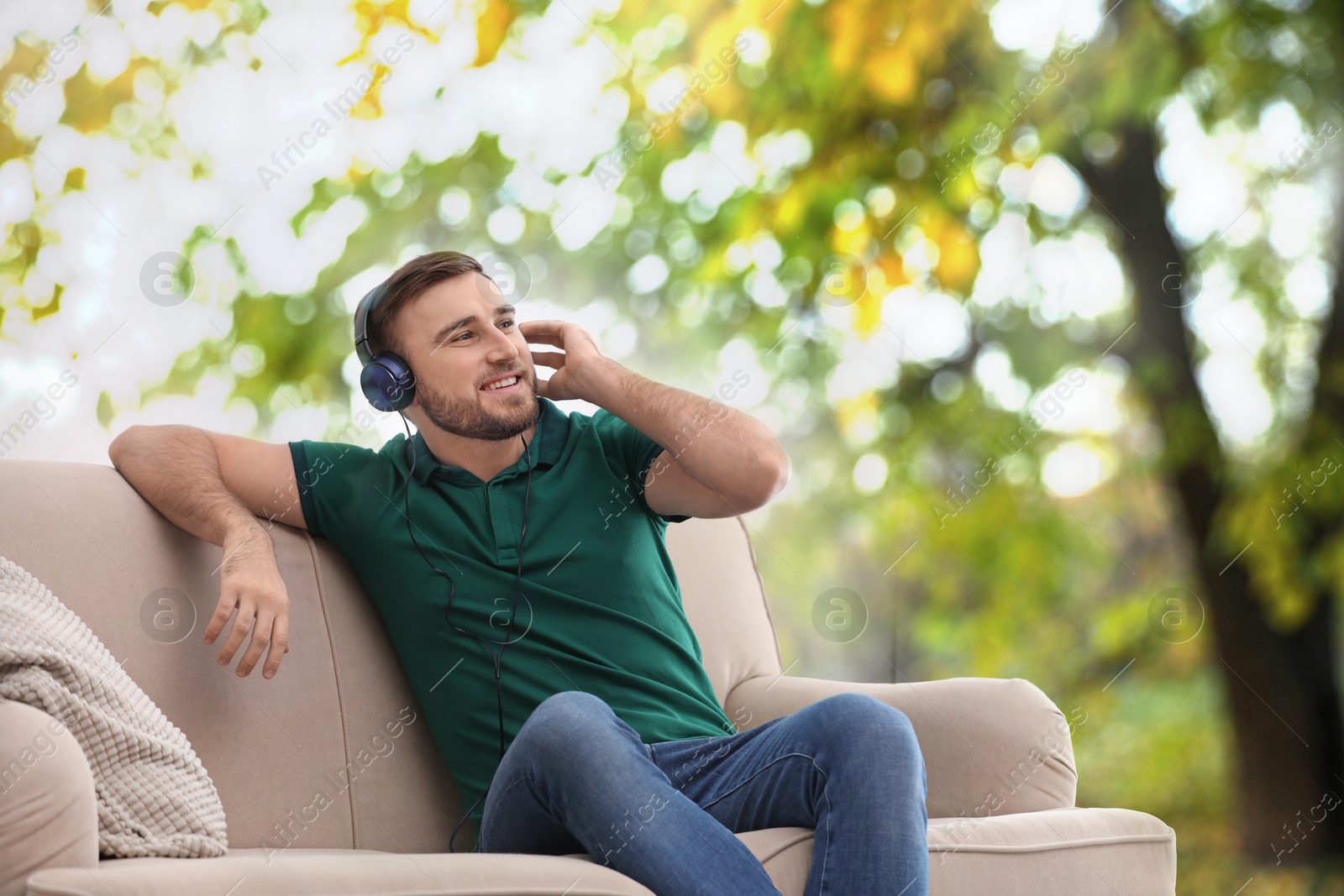 Image of Happy man listening to sounds of nature which making him feel calm. Beautiful landscape on background