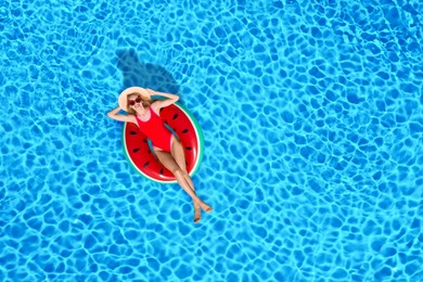 Image of Young happy woman with inflatable ring in swimming pool, top view. Summer vacation