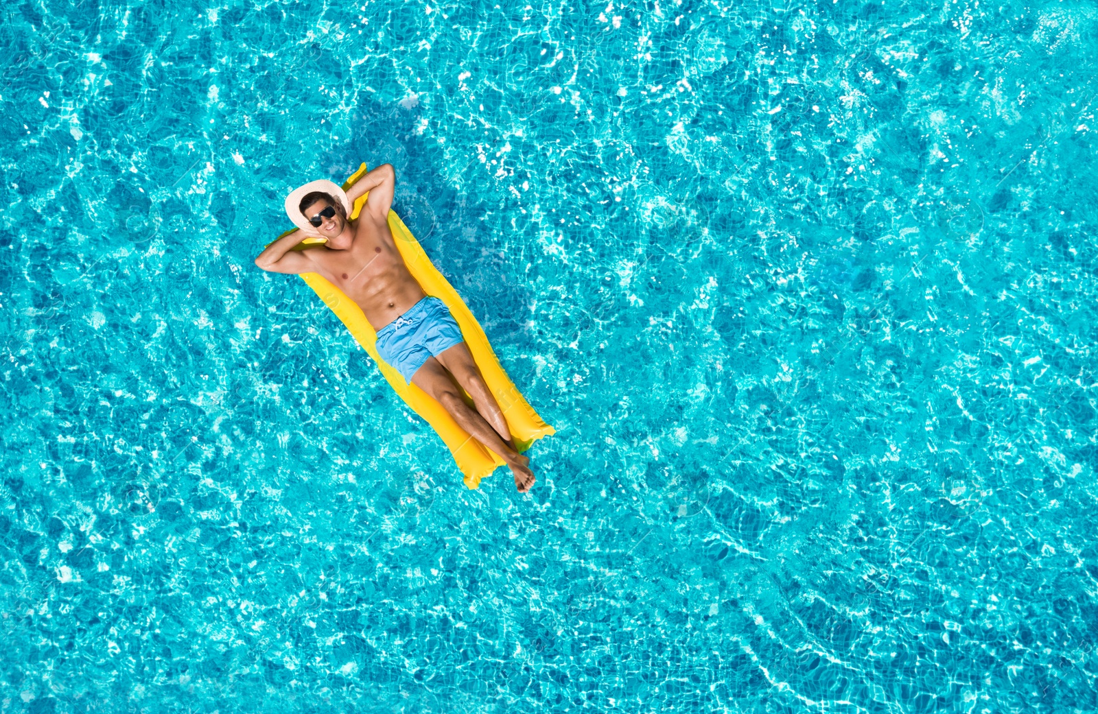 Image of Happy man with inflatable mattress in swimming pool, top view. Summer vacation