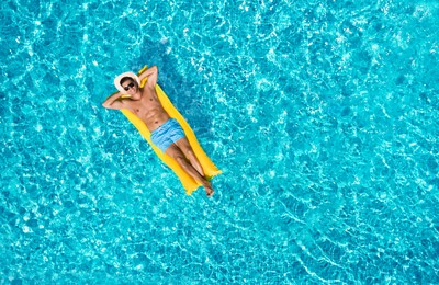 Image of Happy man with inflatable mattress in swimming pool, top view. Summer vacation