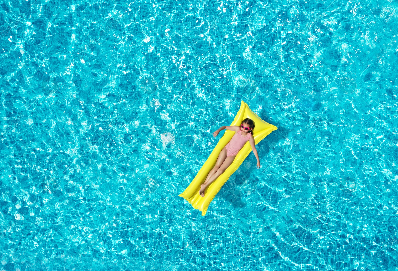 Image of Girl on inflatable mattress in swimming pool, top view. Summer vacation