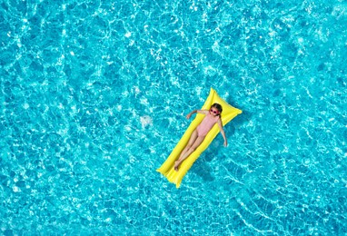 Image of Girl on inflatable mattress in swimming pool, top view. Summer vacation