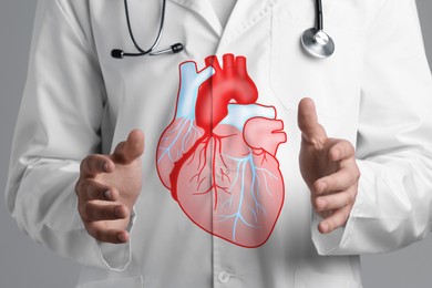 Image of Cardiologist with illustration of heart between hands, closeup