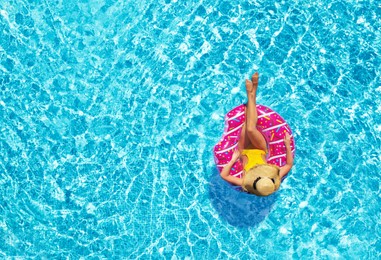 Image of Young woman with inflatable ring in swimming pool, top view
