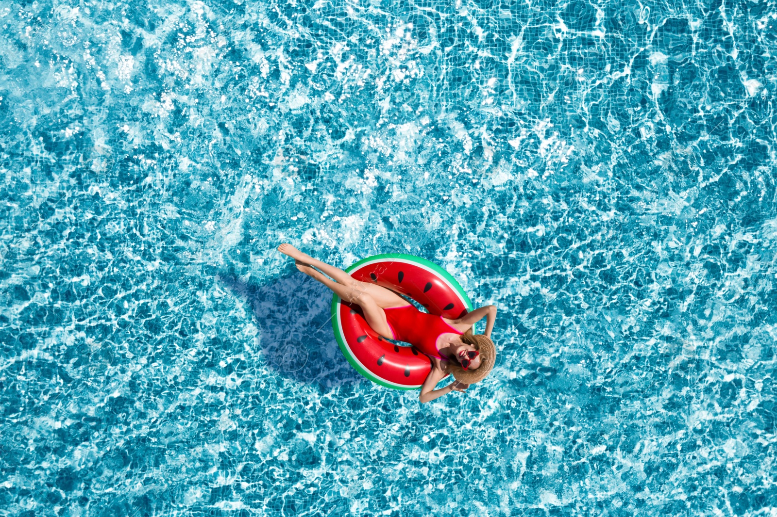 Image of Young happy woman with inflatable ring in swimming pool, top view. Summer vacation