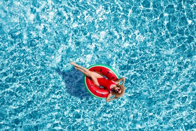 Image of Young happy woman with inflatable ring in swimming pool, top view. Summer vacation