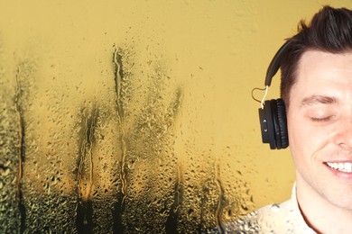 Image of Happy man listening to sounds of nature which making him feel calm. Double exposure with wet window on rainy day