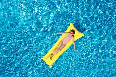 Image of Girl on inflatable mattress in swimming pool, top view. Summer vacation
