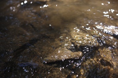 Photo of Many stones under flowing clean water, closeup
