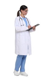 Photo of Smiling doctor in uniform, stethoscope and glasses writing on clipboard against white background