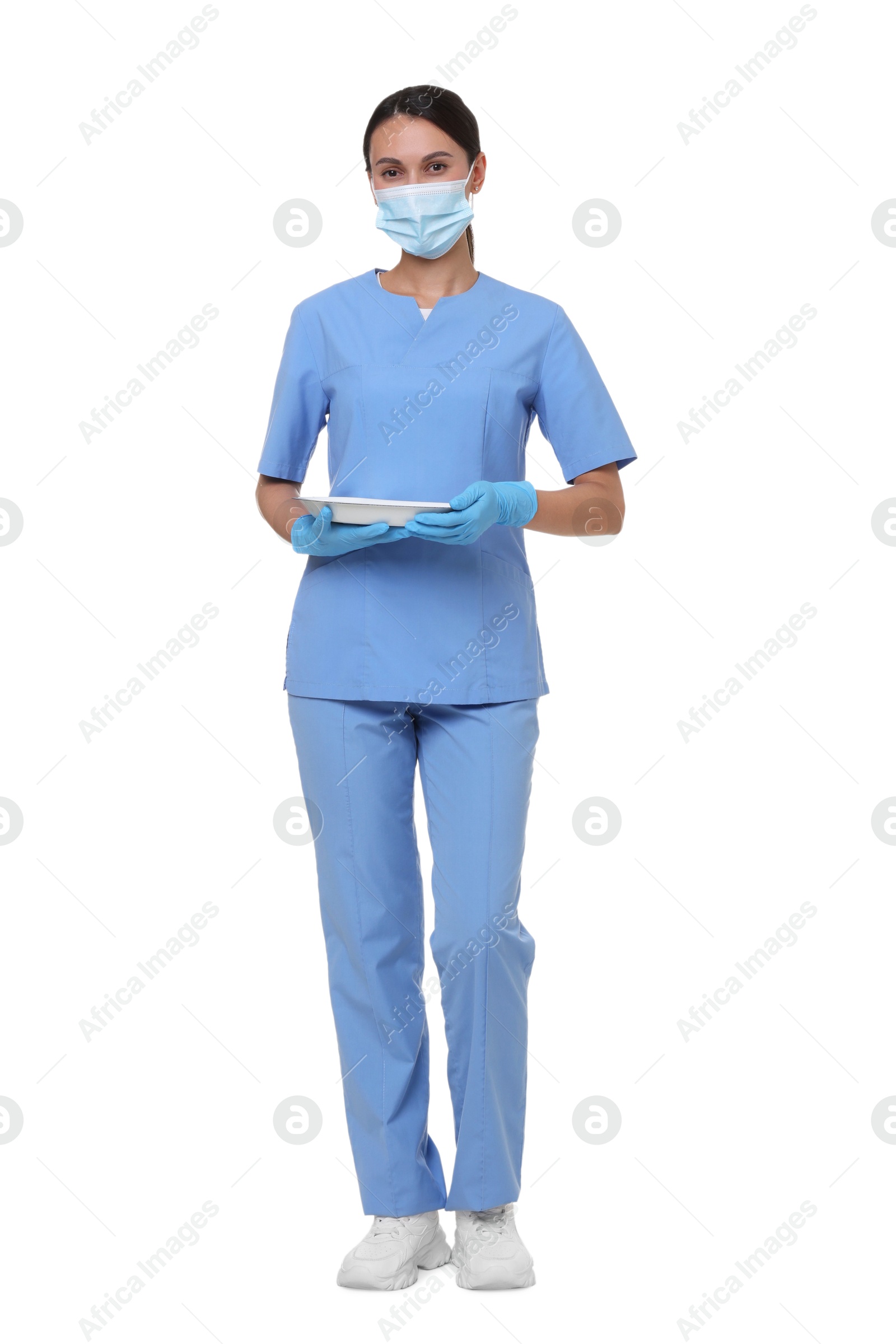 Nurse in uniform, medical mask and protective gloves with tray on white background Photo of Nurse in uniform, medical mask and protective gloves with tray on white background