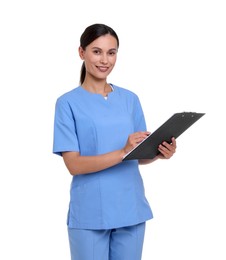 Photo of Smiling nurse in uniform writing on clipboard against white background