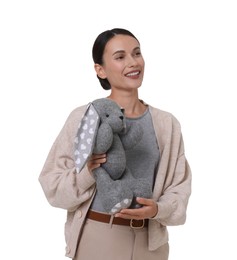 Photo of Smiling nursery teacher with toy rabbit on white background