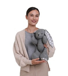 Photo of Smiling nursery teacher with toy rabbit on white background