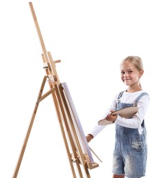 Photo of Choice of profession. Little girl with palette of paints and brush near easel pretending to be artist on white background