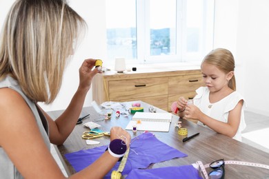 Photo of Choice of profession. Little girl helping her mother working in atelier