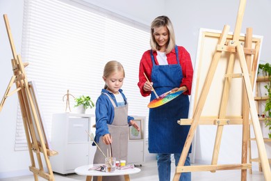 Photo of Choice of profession. Mother teaching her daughter to paint in studio