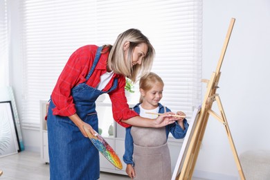 Photo of Choice of profession. Mother teaching her daughter to paint in studio
