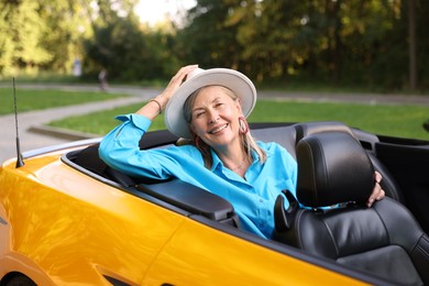 Photo of Stylish senior woman in modern cabriolet outdoors