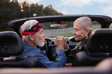 Photo of Stylish senior couple in modern cabriolet outdoors