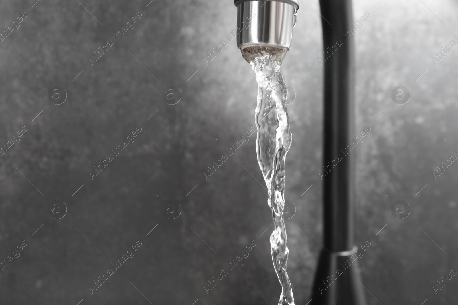 Water dripping down from faucet on grey background, closeup. Space for text Photo of Water dripping down from faucet on grey background, closeup. Space for text