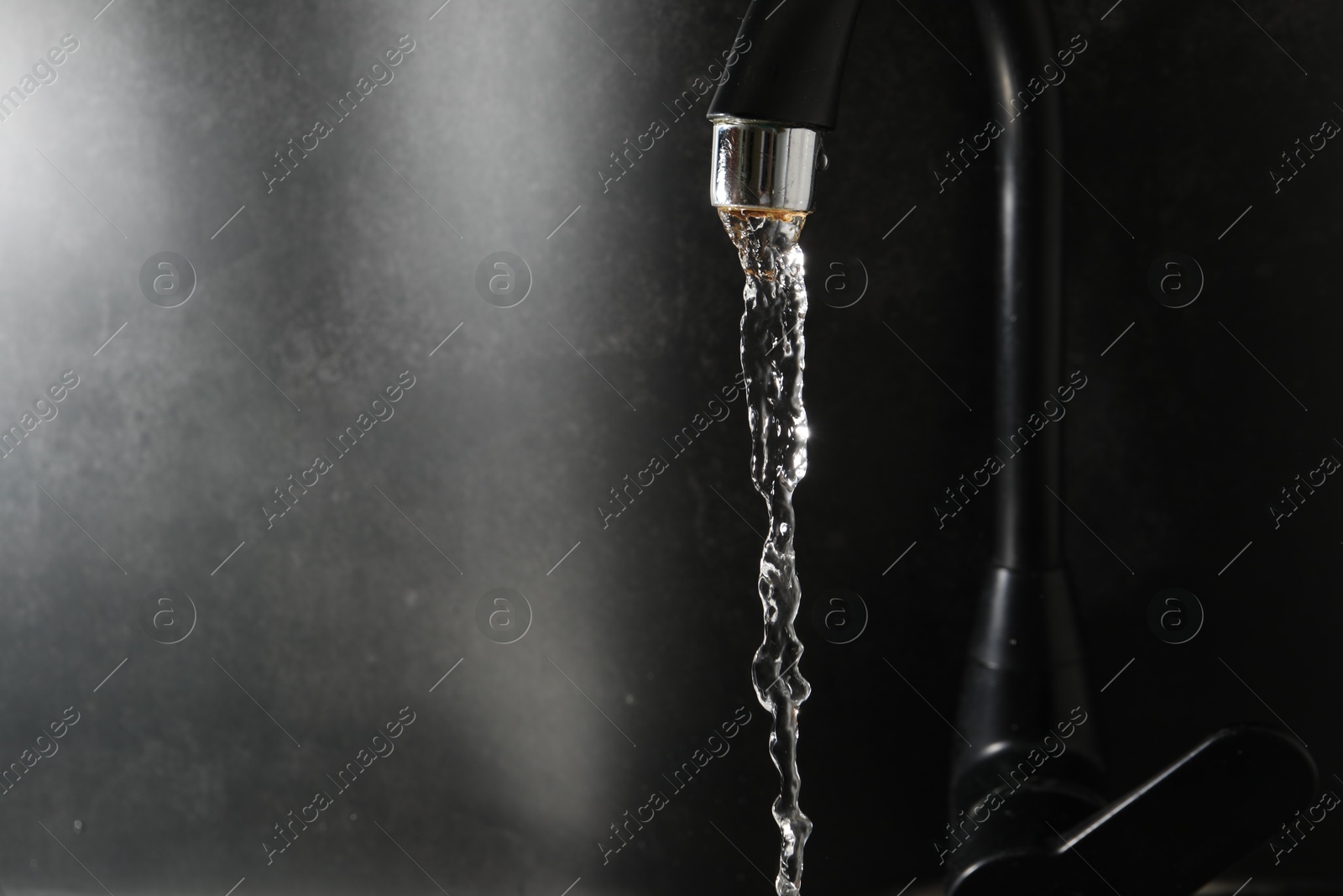 Water dripping down from faucet on grey background, closeup. Space for text Photo of Water dripping down from faucet on grey background, closeup. Space for text