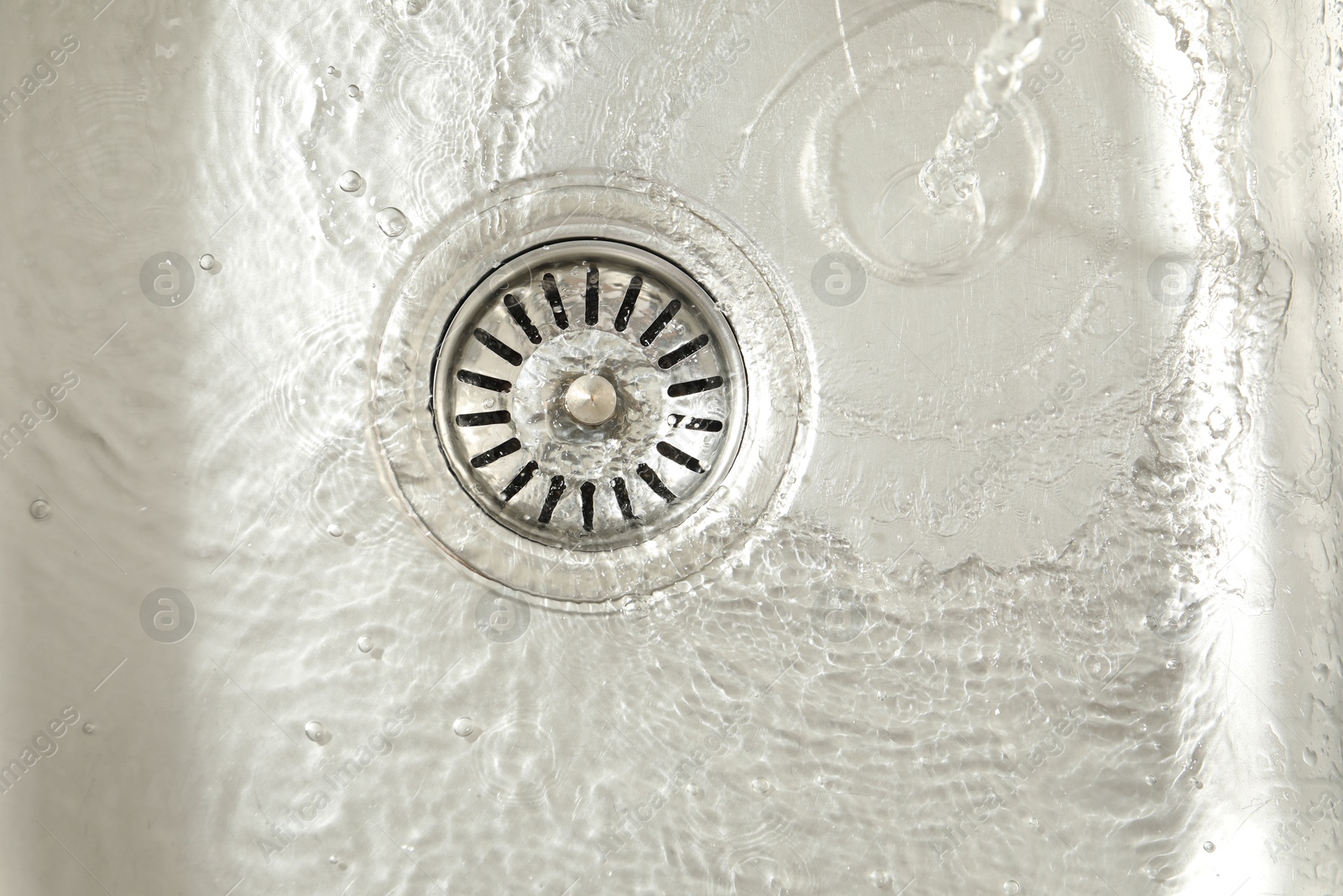 Photo of Water going down sink drain, top view